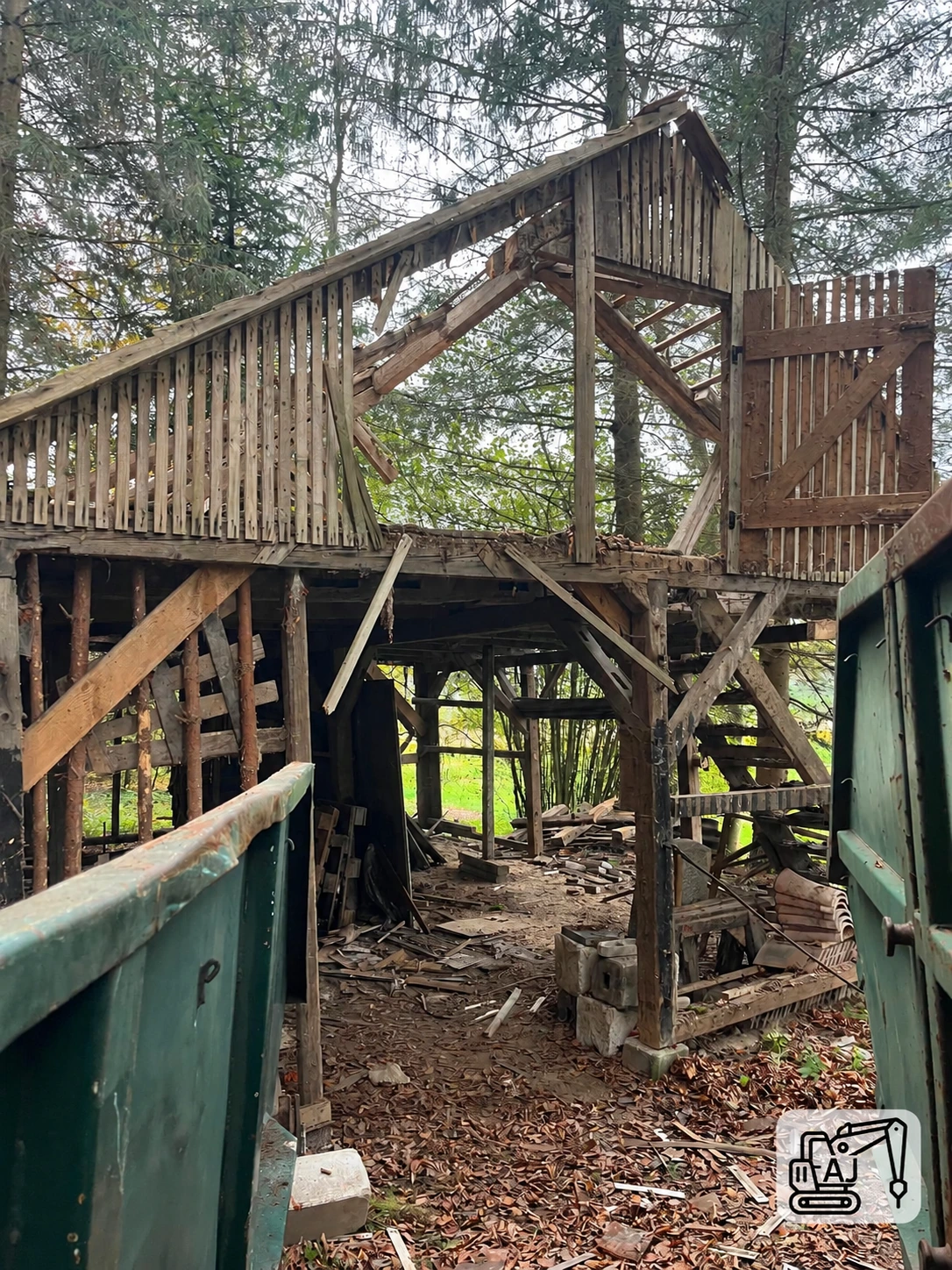 Teilweise zurückgebaute Holzkonstruktion mit freigelegten Stützen und Dachbauteilen.